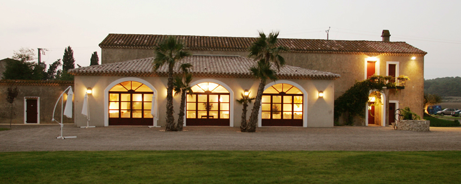 Vue extérieure de nuit de la salle de réception pour votre mariage de la Bergerie de la Vernède dans l'Hérault